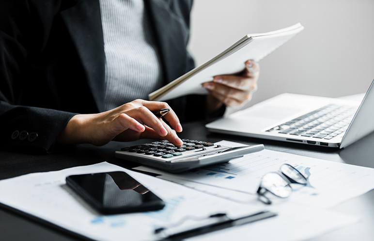 Close up of businesswomen or accountant using calculator calculate while working analytic business report
